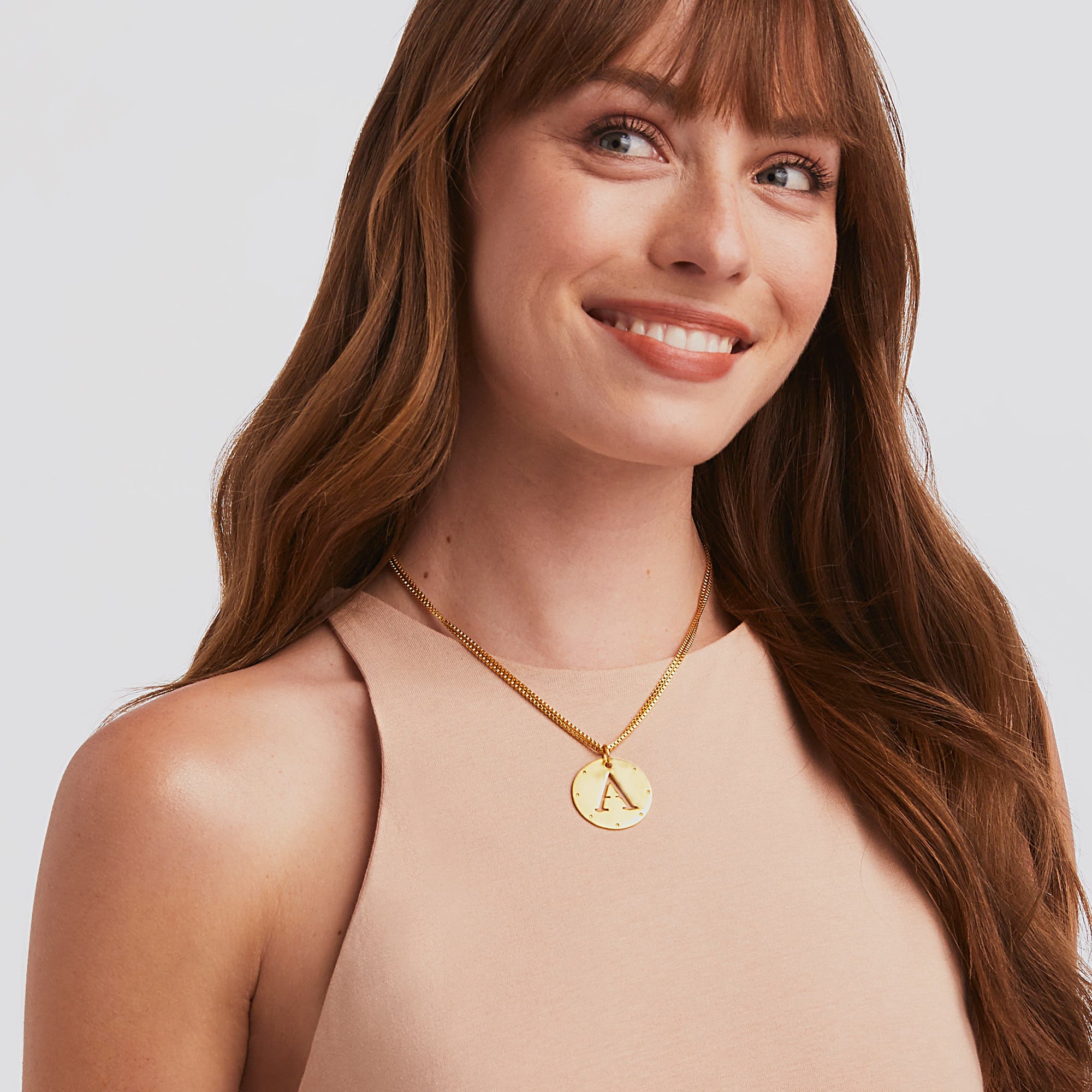 carousel, {{ PDP Monogram Gold Pendant Necklace in the letter A shown doubled on model }}